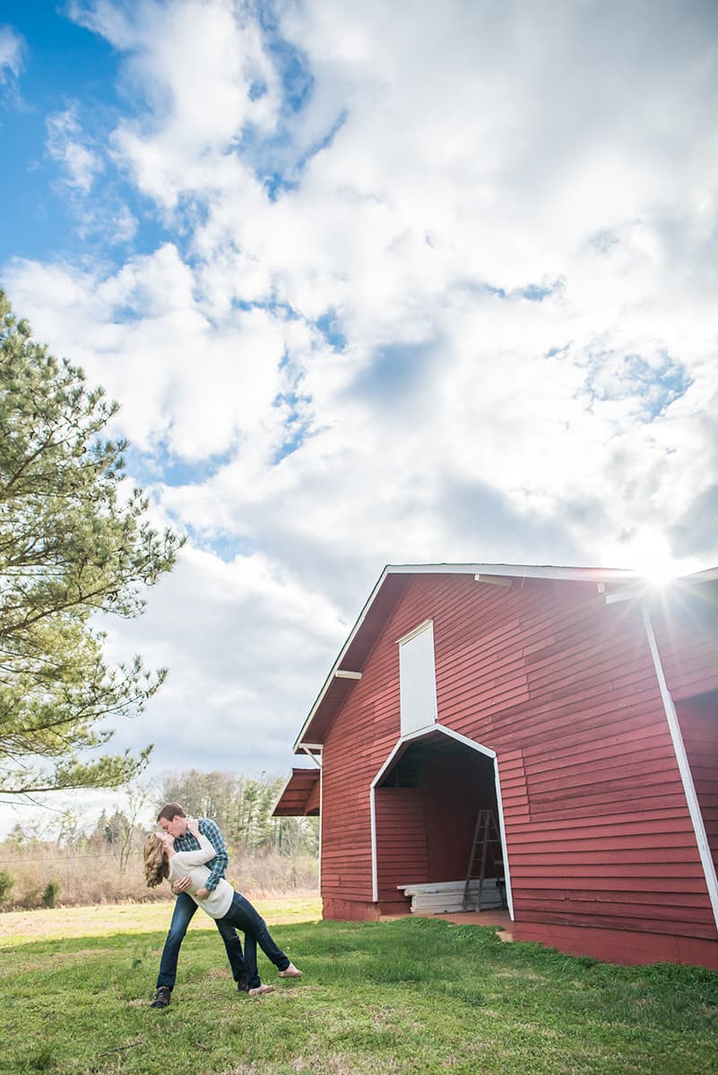 Red barn and blue sky engagement pictures located in Greenville, SC