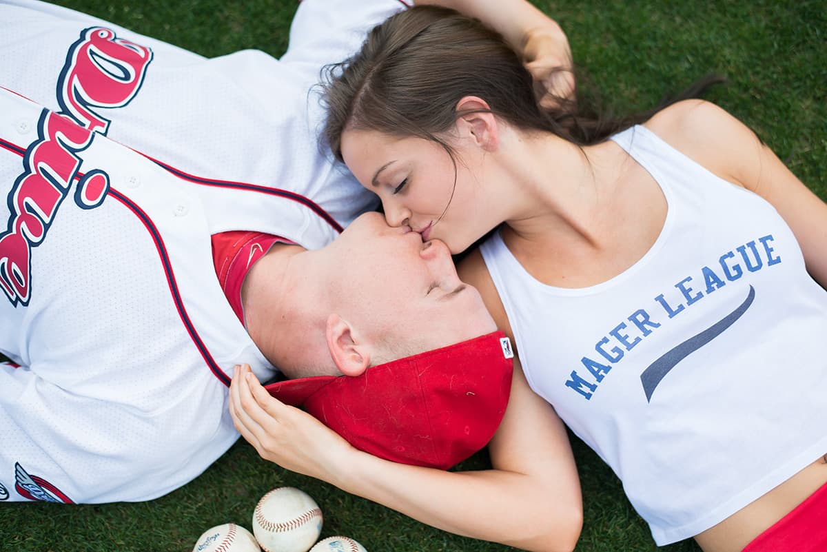 Baseball engagement pictures at Greenville Drive stadium with baseballs on the field