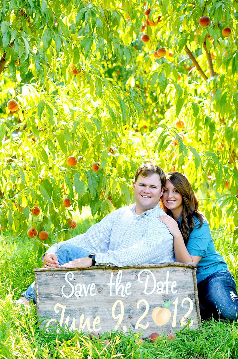 Peach orchard engagement pictures for Save the Date card with a date sign