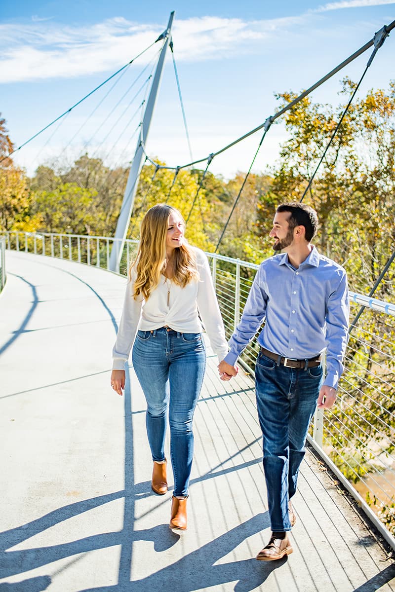 Couple walking across Liberty Bridge in Falls Park on the Reedy, downtown Greenville, SC